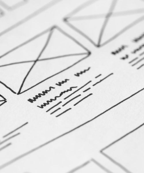 Detailed close-up of a hand-drawn wireframe design on paper for a UX project.